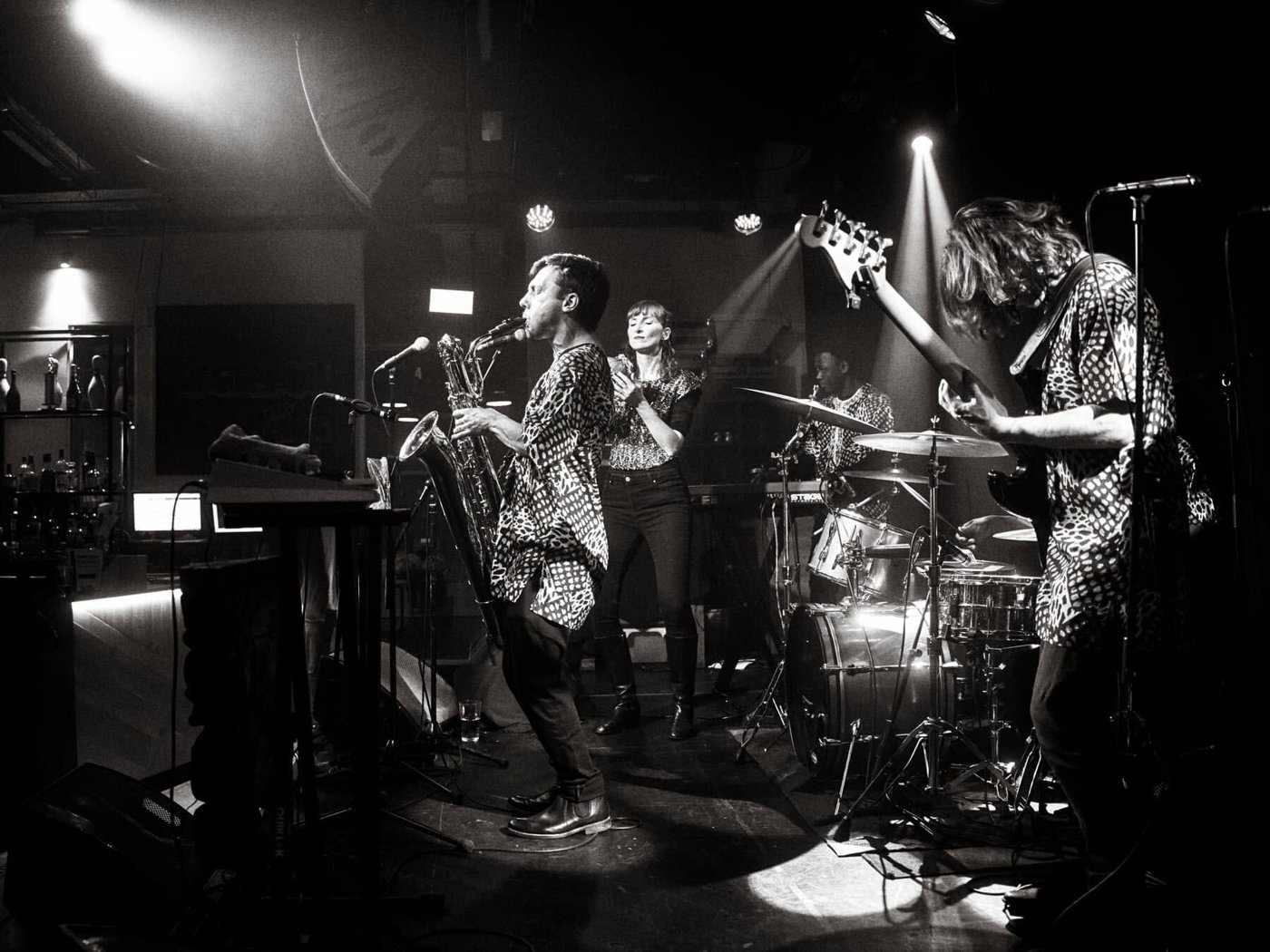 Sebastian playing baritone saxophone on stage with a band